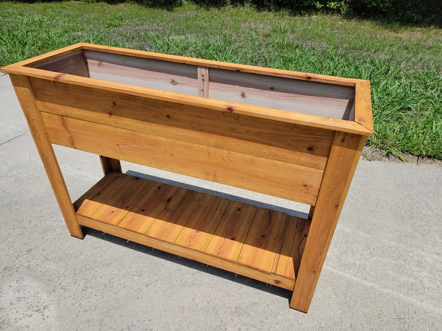 Raised cedar planter box with a lower storage shelf, finished and set outdoors